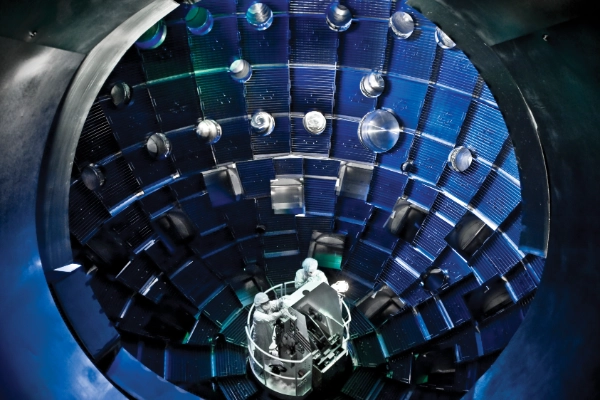 Scientists in white suits inside a chamber