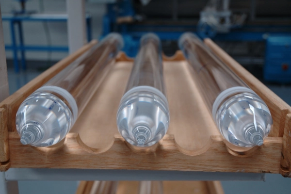 Drei Quarzglaszylinder  liegen auf einem speziellen Holztablett mit Ausbuchtungen, damit die Zylinder nicht wegrollen