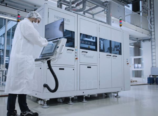 Worker in a white coat works at the terminal of the Industrial Inkjet Projector 